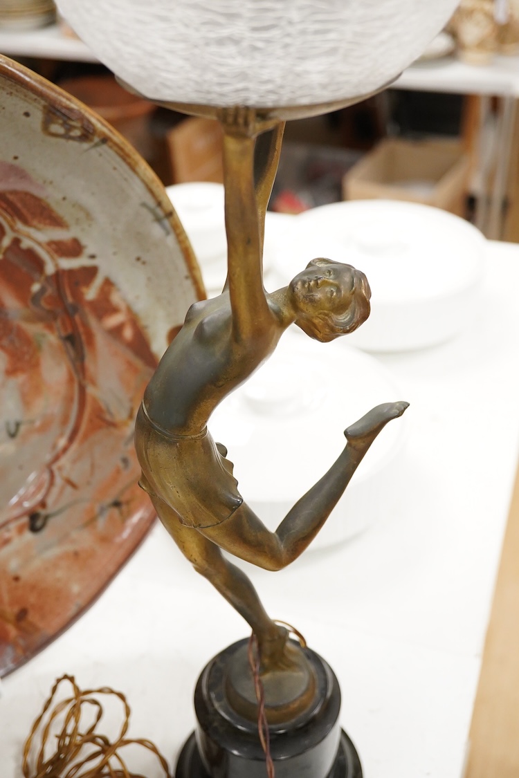 An Art Deco spelter ‘Dancing Girl’ table lamp with a frosted glass globe shade, 57cm high